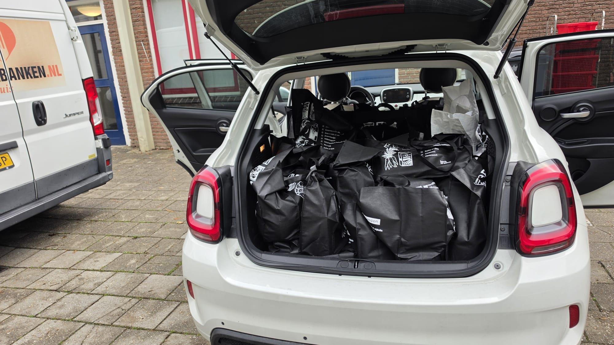 Auto vol ingezamelde boodschappentassen voor Voedselbank Voorne aan Zee